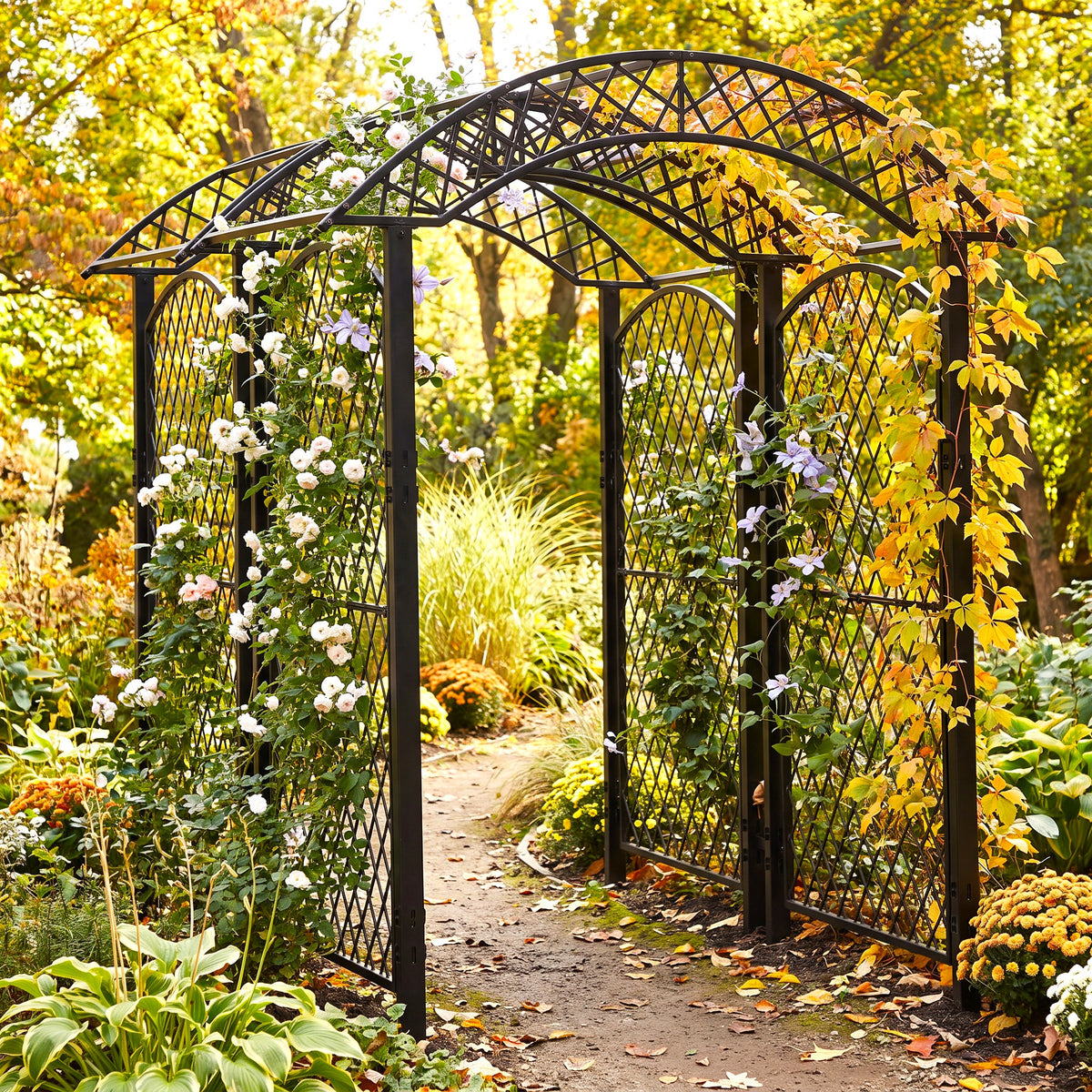 h potter brand black metal arched garden trellis with lattice panels, shown in a lush garden setting with climbing white and purple flowers, autumn foliage, and a dirt path.