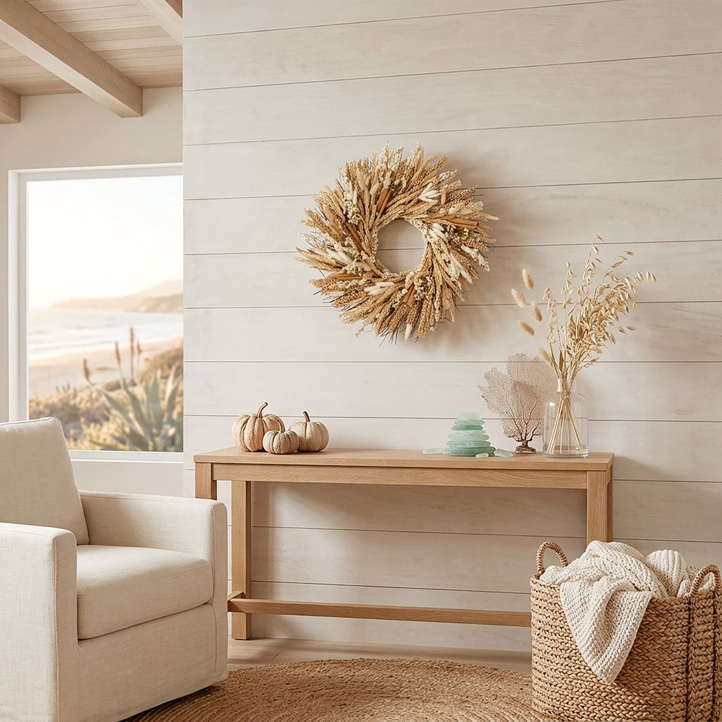 h potter brand natural beige dried grass wreath wall decor piece hanging on a light wood shiplap wall above a wooden console table in a bright, modern coastal living room.
