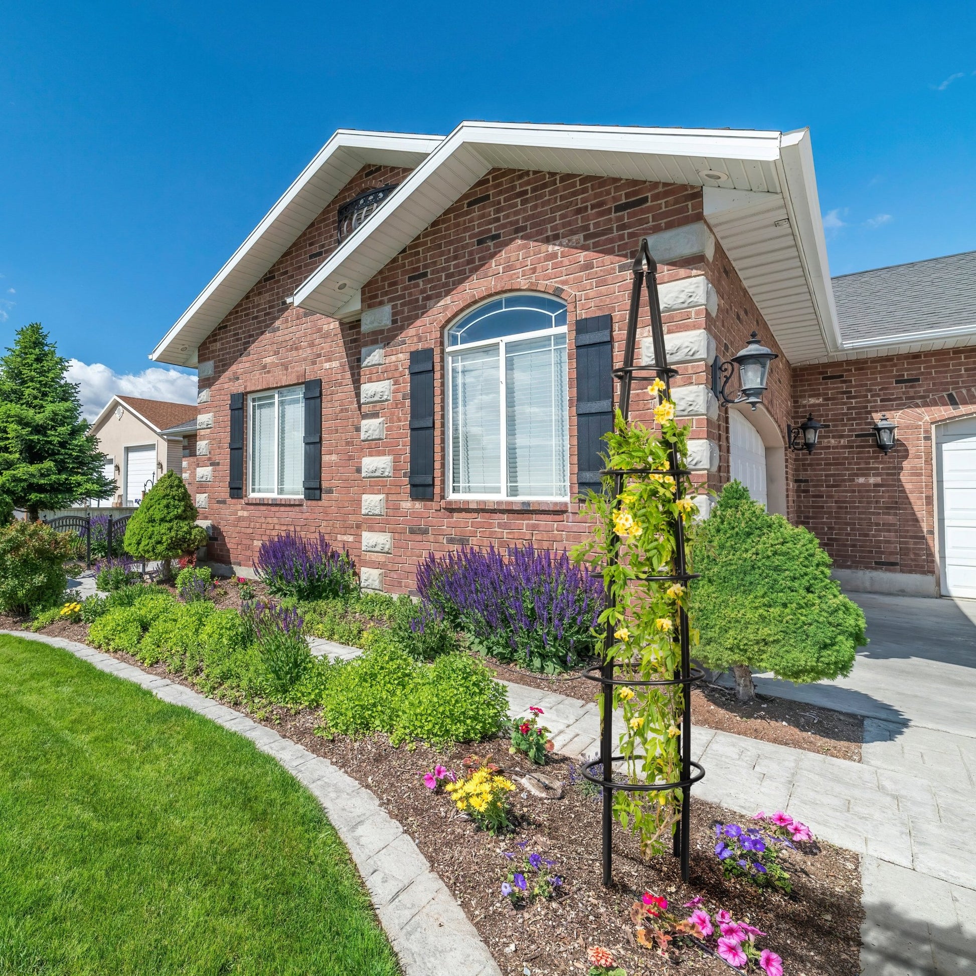 H Potter grand black metal garden obelisk trellis installed in front yard landscaping