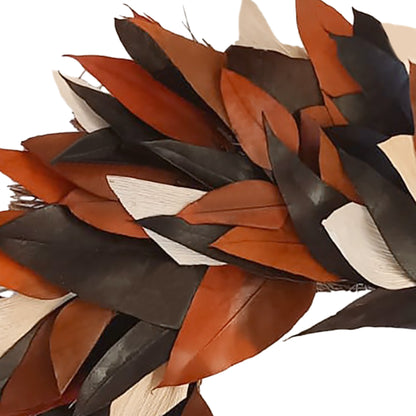 A close-up of layered feathers in warm brown, black, and off-white tones against a plain white background.