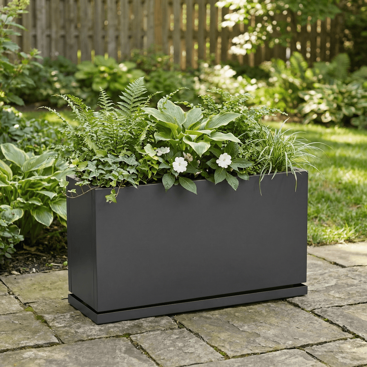 H Potter Hawthorne grey planter on backyard stone patio with green plant