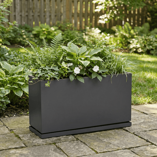 H Potter Hawthorne grey planter on backyard stone patio with green plant