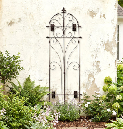 H Potter Italian Wall Trellis on a stucco house above landscaped garden plants