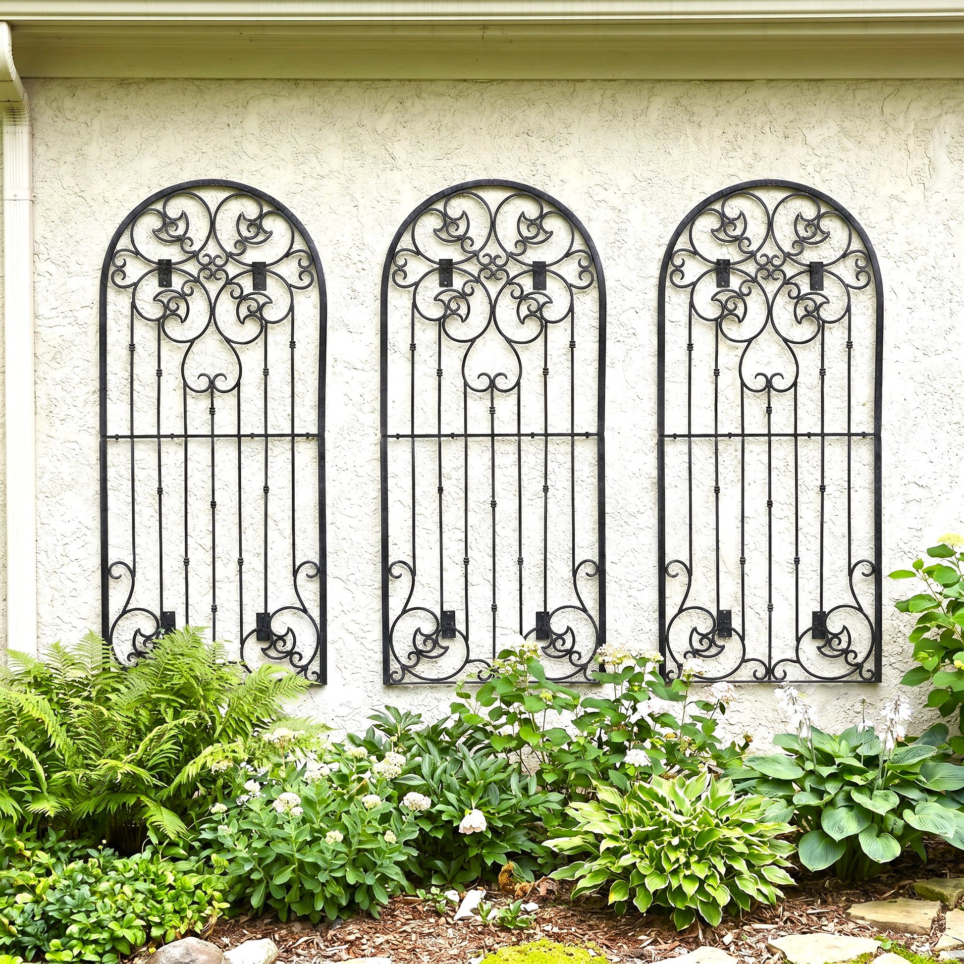 h potter metal garden wall trellises on a house with hostas in landscaping