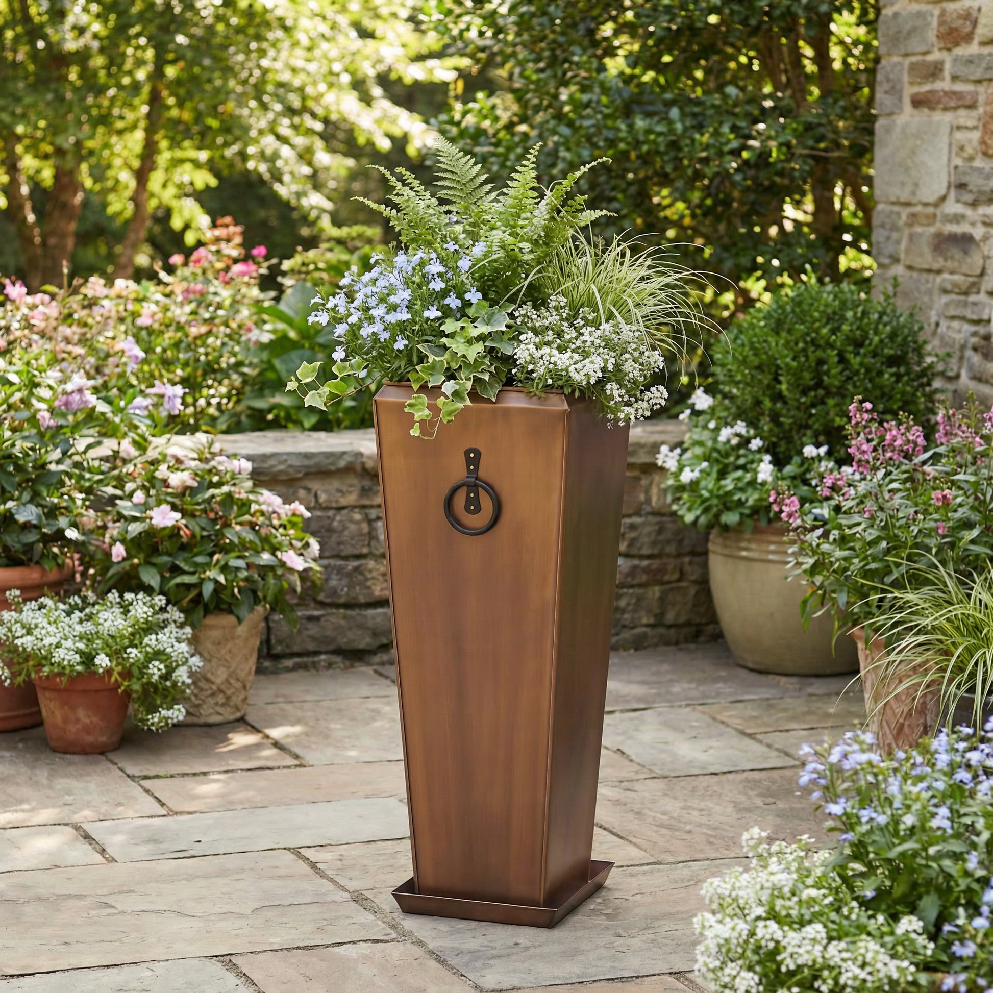 H Potter copper garden planter in backyard landscape on stone patio with green plants