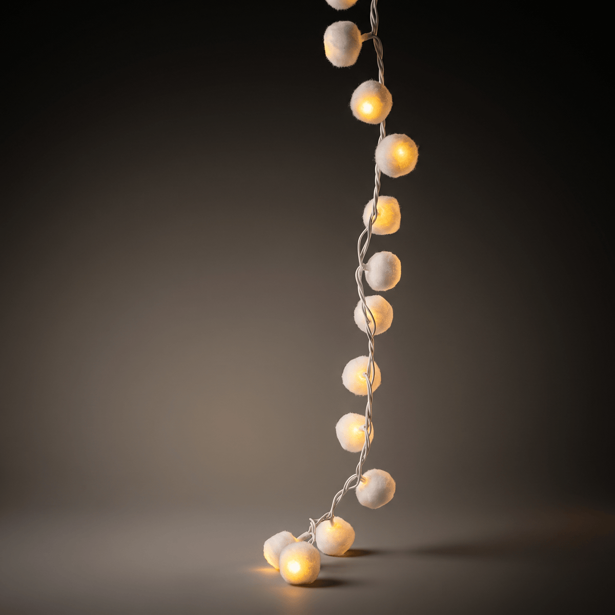 h potter string of warm white globe fairy lights draped vertically against a dark gray gradient background.