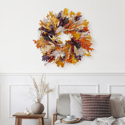 H Potter dried colorful autumn wreath on a white wall above a sofa with decorative pillows.