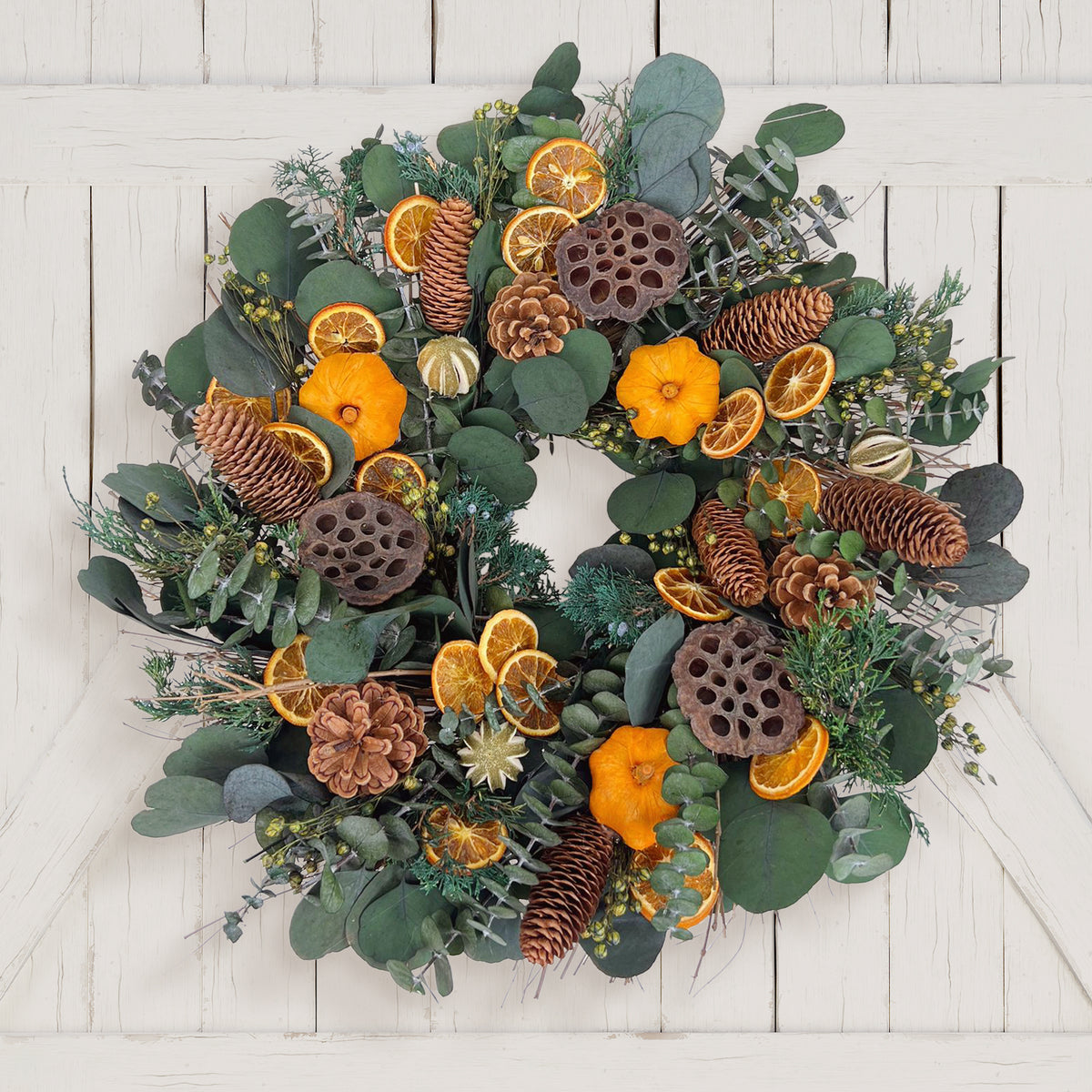 H Potter preserved decorative wreath with greenery, pine cones, and oranges on a white wooden background