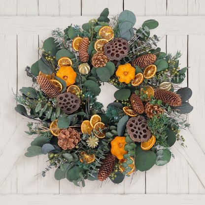 H Potter preserved decorative wreath with greenery, pine cones, and oranges on a white wooden background