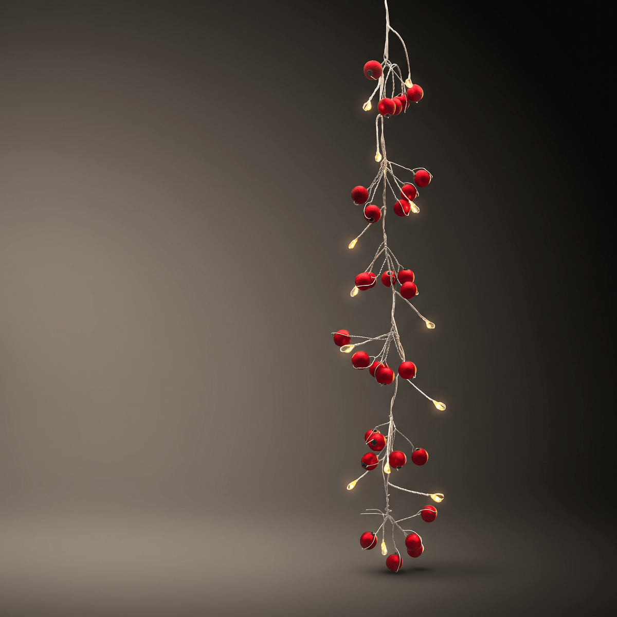 h potter vertical hanging garland of red berry-shaped string lights with small warm white bulbs on a dark gray gradient background.