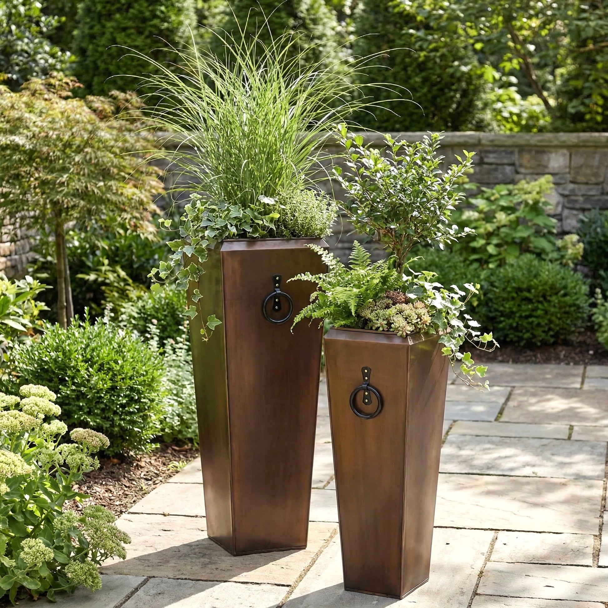 h potter set of 2 santa fe tall planters on a stone patio outdoors with green plants