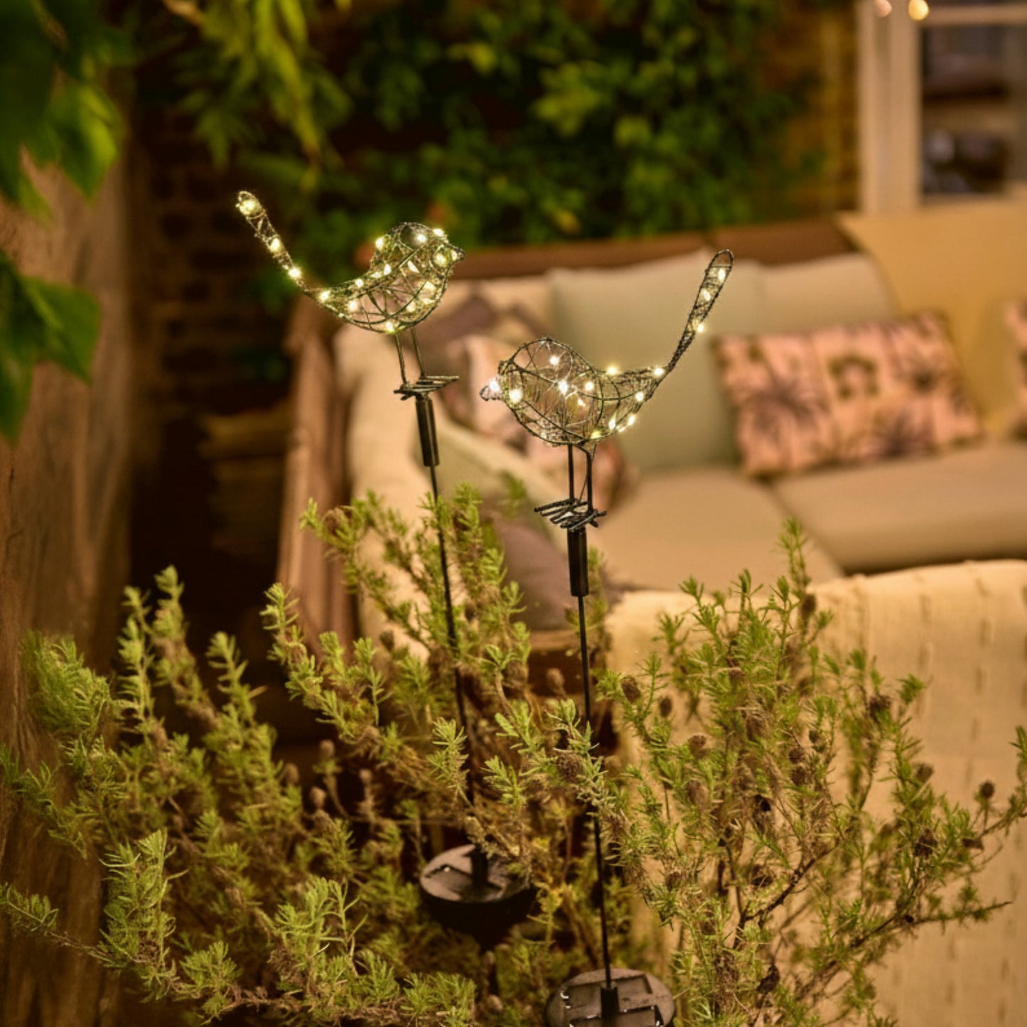 h potter solar sparrows staked in a garden pot on a deck