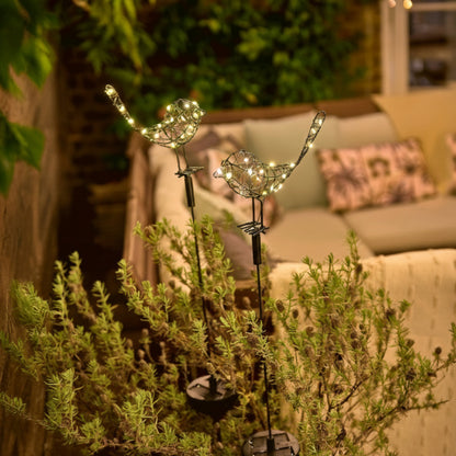 h potter solar sparrows staked in a garden pot on a deck