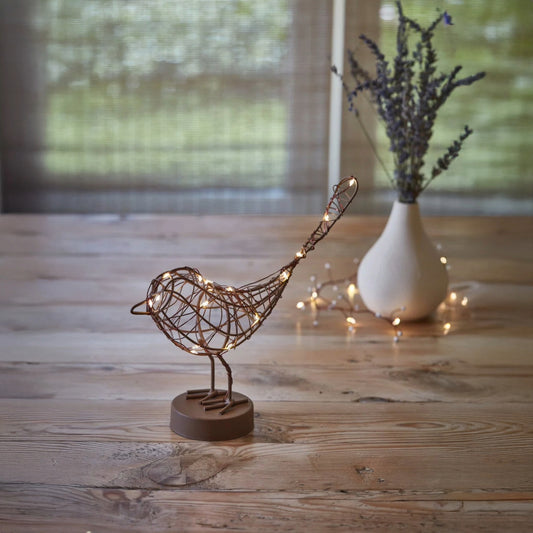 H Potter decorative metal bird with  led lights on a wooden surface with a blurred background