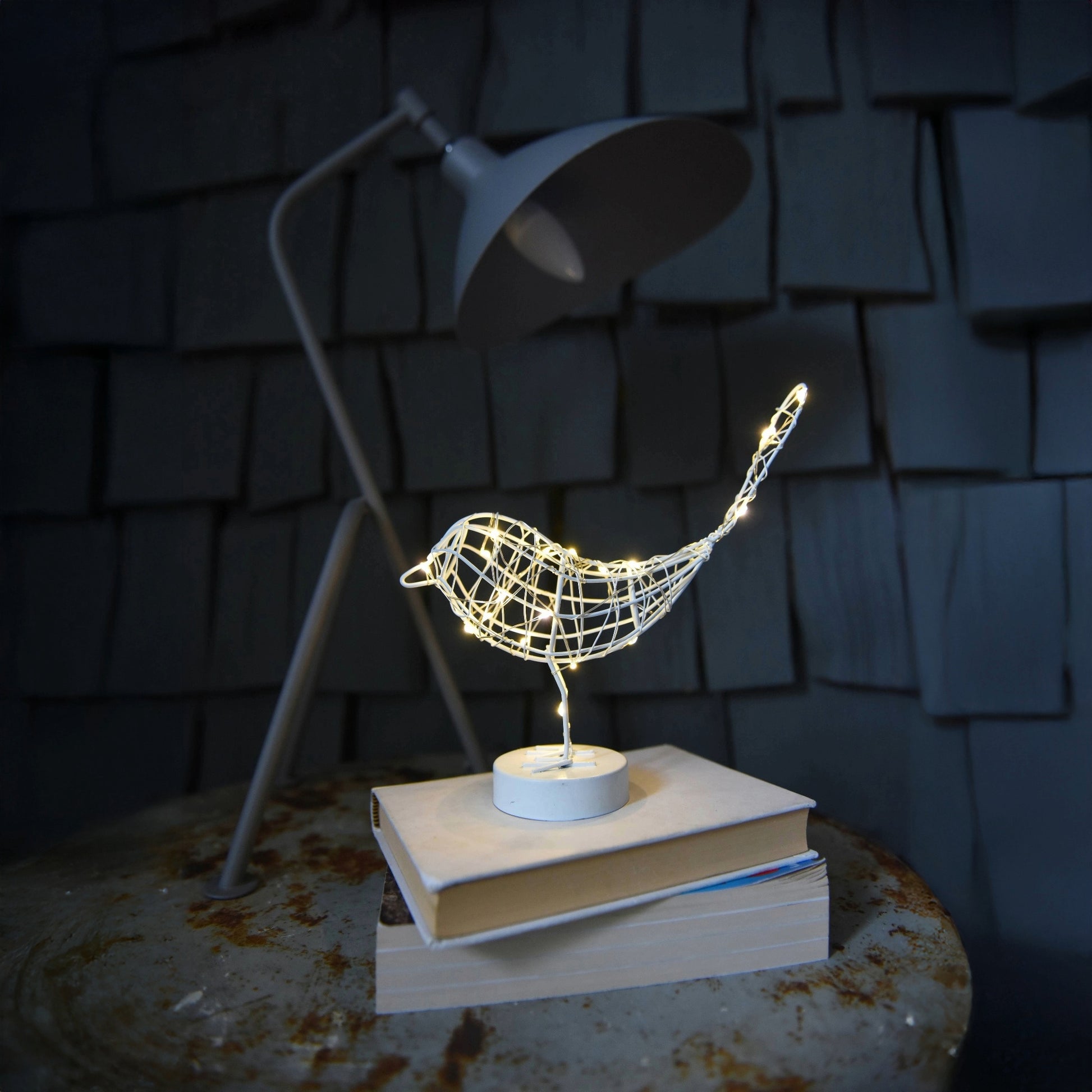 H Potter metal sparrow with LED lights and sitting on a book with a dark background