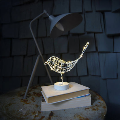 H Potter metal sparrow with LED lights and sitting on a book with a dark background