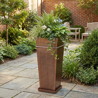 h potter tall garden planter outdoors on stone patio with green plants