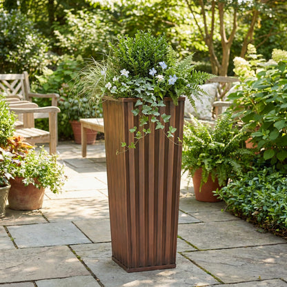 H Potter 36 inch planter on stone patio with green plants metal planter