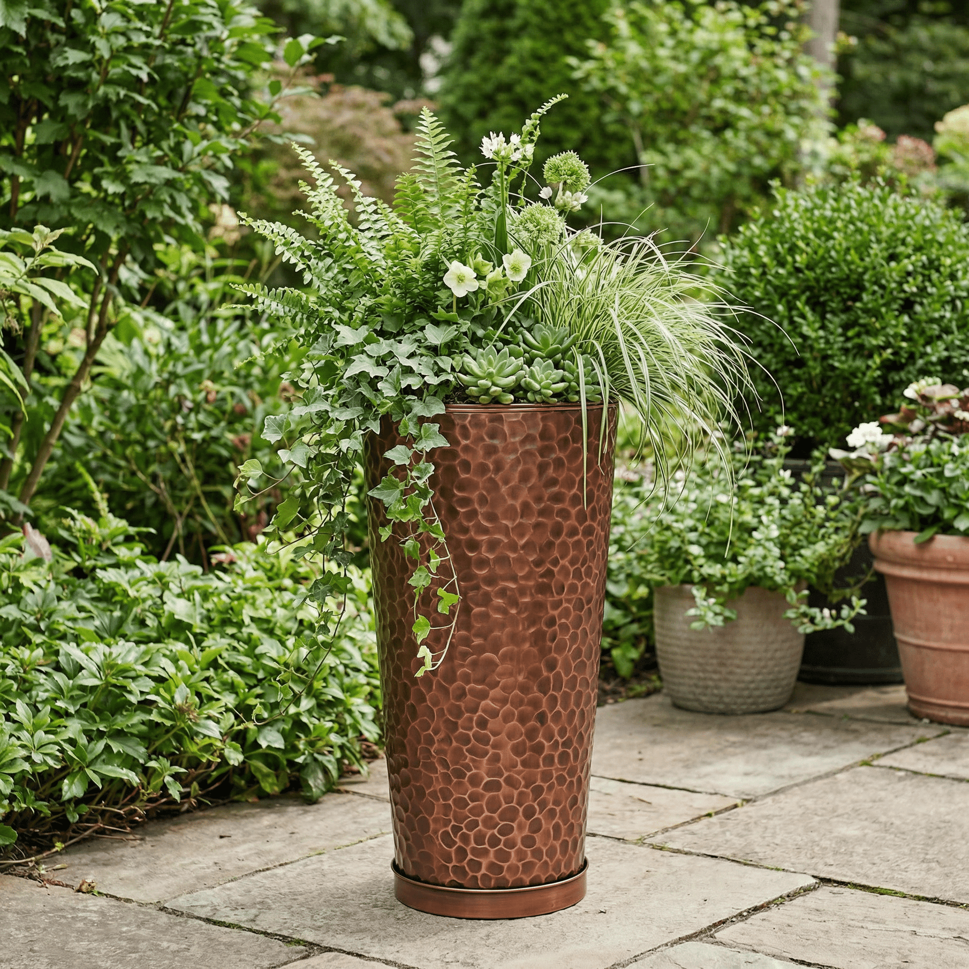 h potter tall column planter in a garden on a stone patio