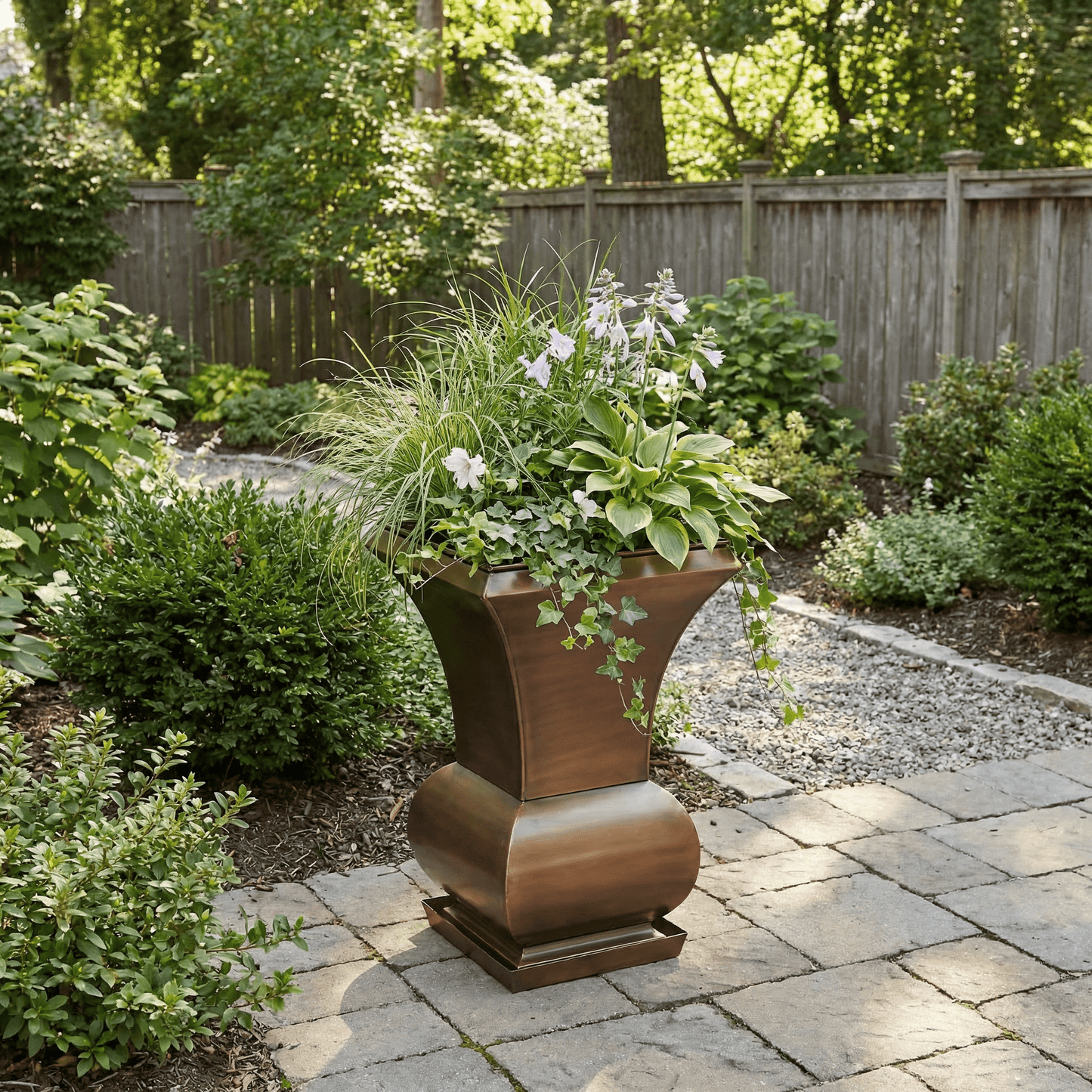H Potter garden planter in backyard landscape with green plants, ivy and grasses