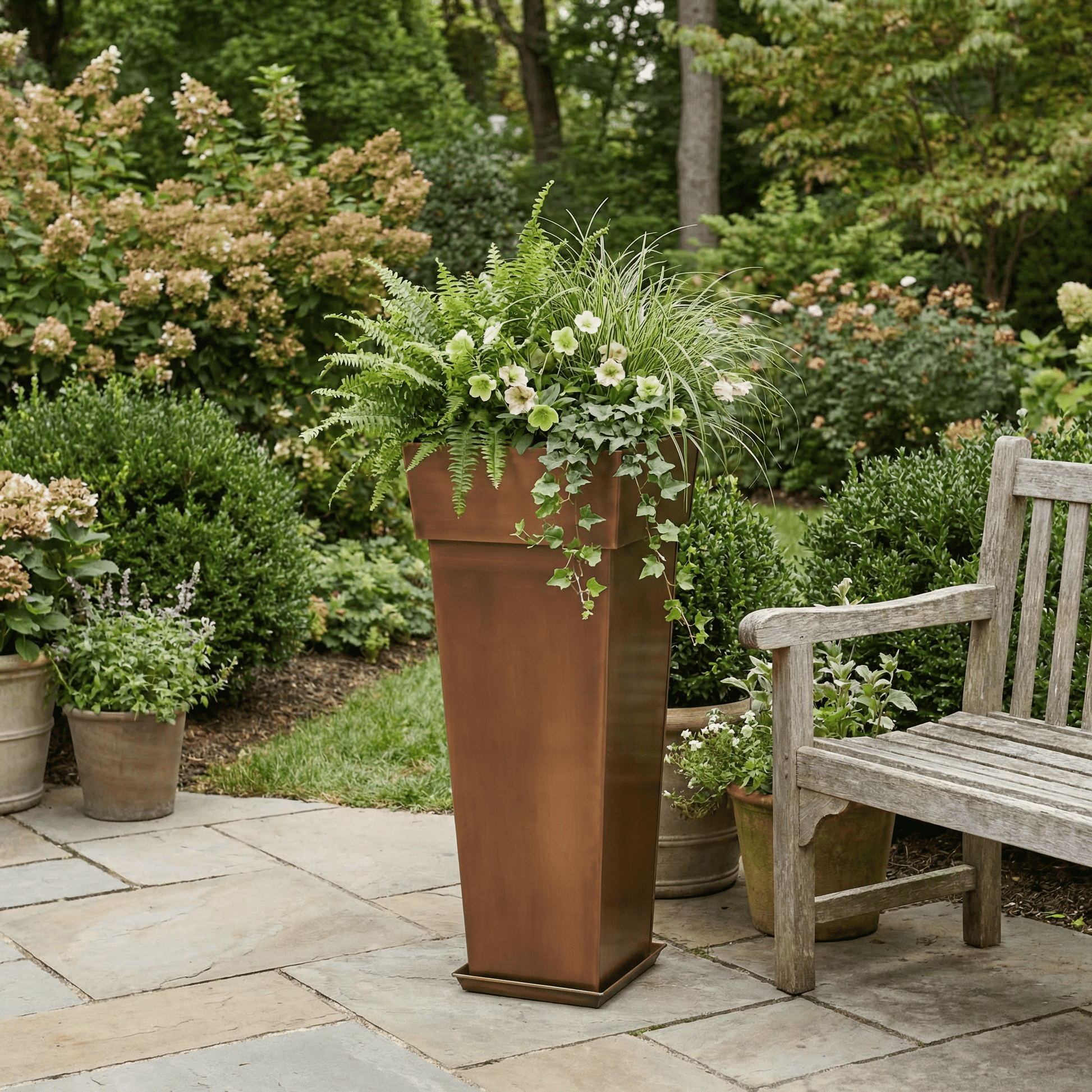 H Potter 36 inch tall garden planter on a stone patio with green plants