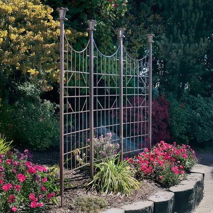 H Potter three-panel metal garden trellis screen in charcoal brown finish, freestanding in a landscaped garden setting