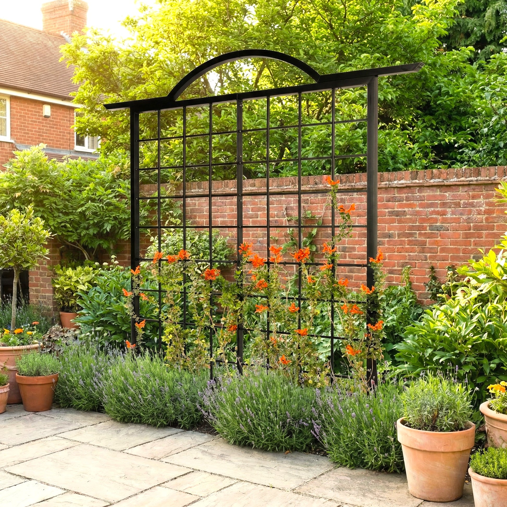 h potter black large trellis in a garden with orange flowers on a stone patio