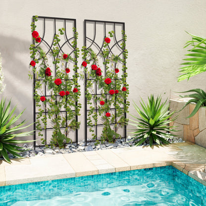 Decorative metal trellises with green vines and red flowers by a pool