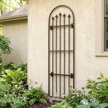 H Potter Verona wall trellis metal with black finish on stucco house above hostas