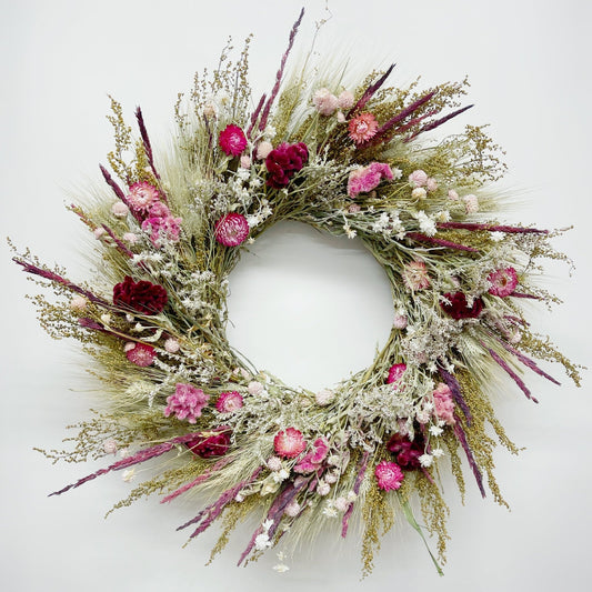 Floral wreath with pink and red flowers on a white background