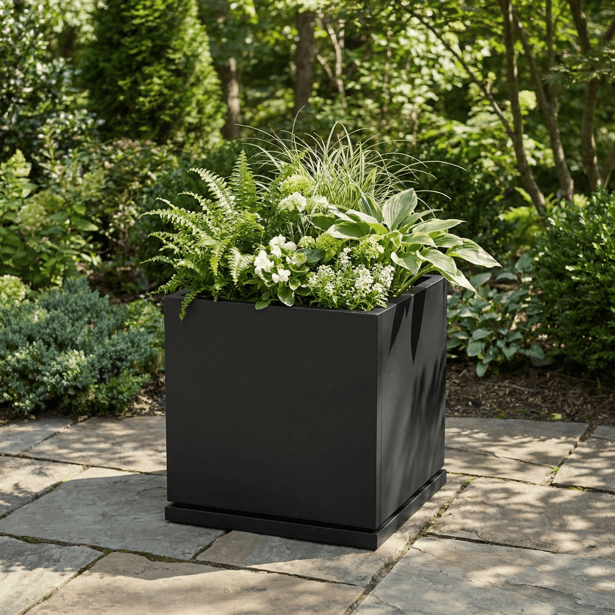 h potter Willow black square planter on stone patio 
