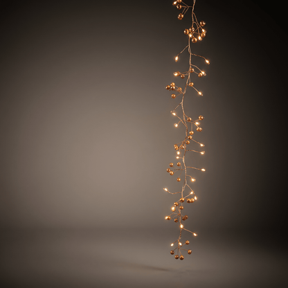 h potter vertical strand of woodland berry LED fairy lights and small gold-toned berry accents, photographed against a dark gray gradient studio background.