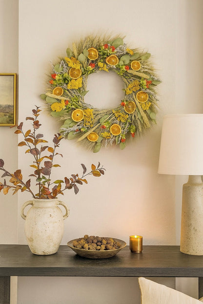 H Potter dried golden citrus bloom wreath above console table on white wall