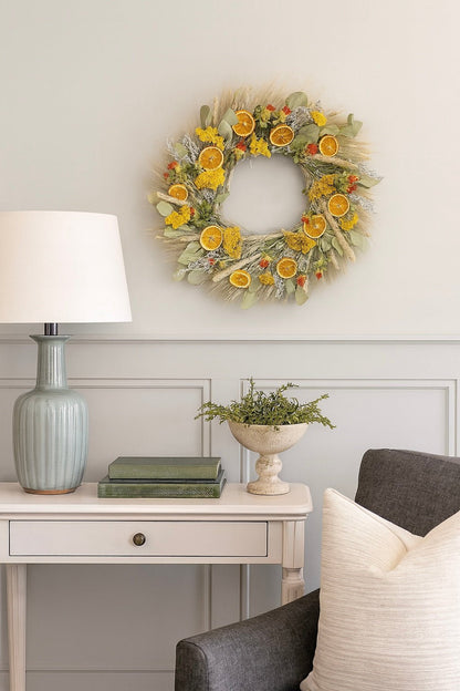 H Potter dried golden citrus wreath with eucalyptus, tansy, nigella, lemon mint, pine cones, orange slices on living room wall