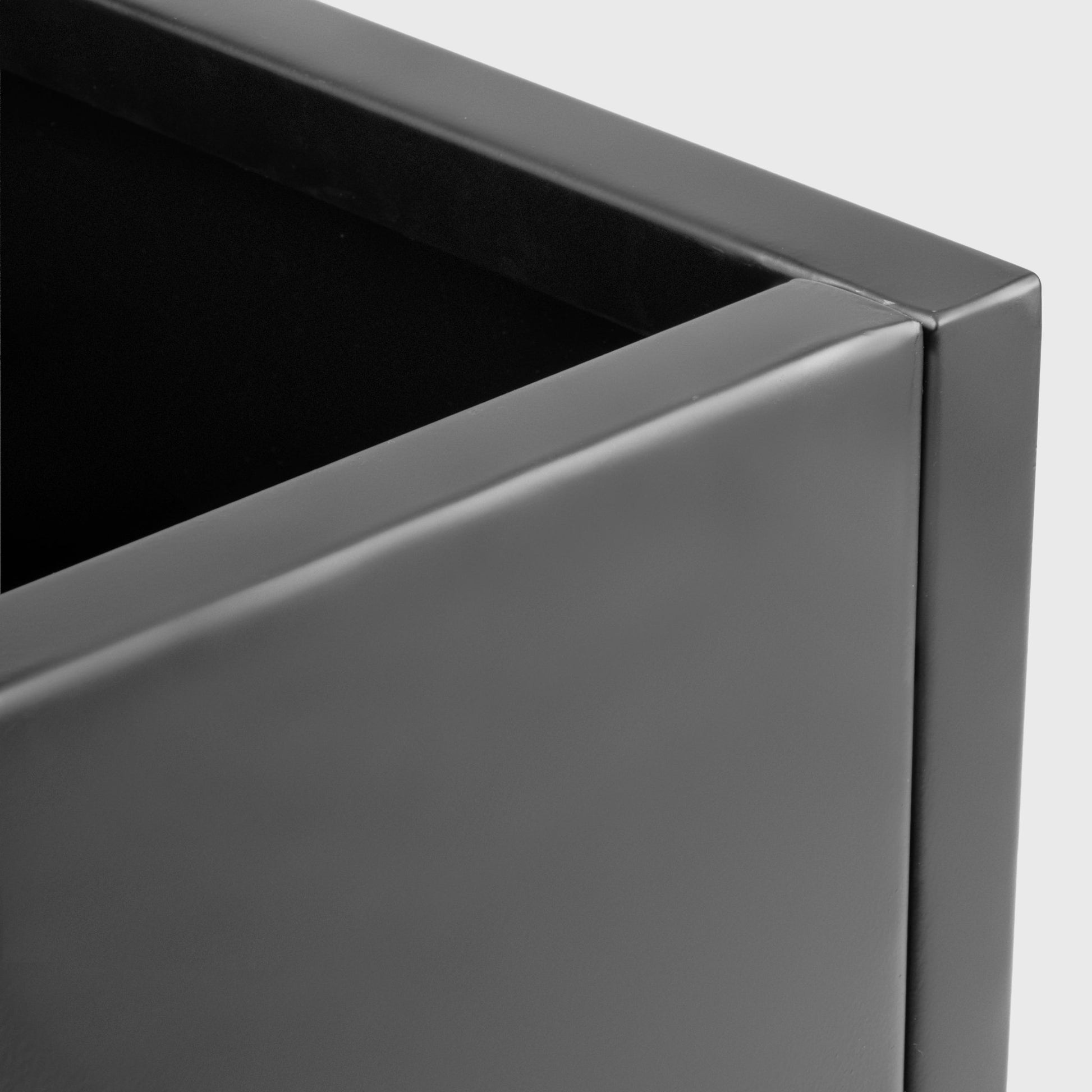 Close-up of a gray metal planter box on a light gray background