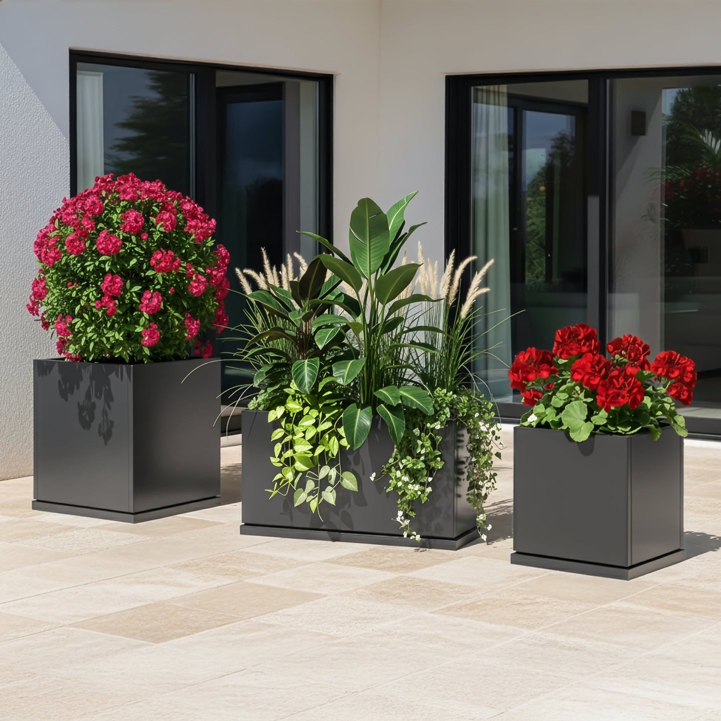 Three H Potter grey planters with flowers on a contemporary patio