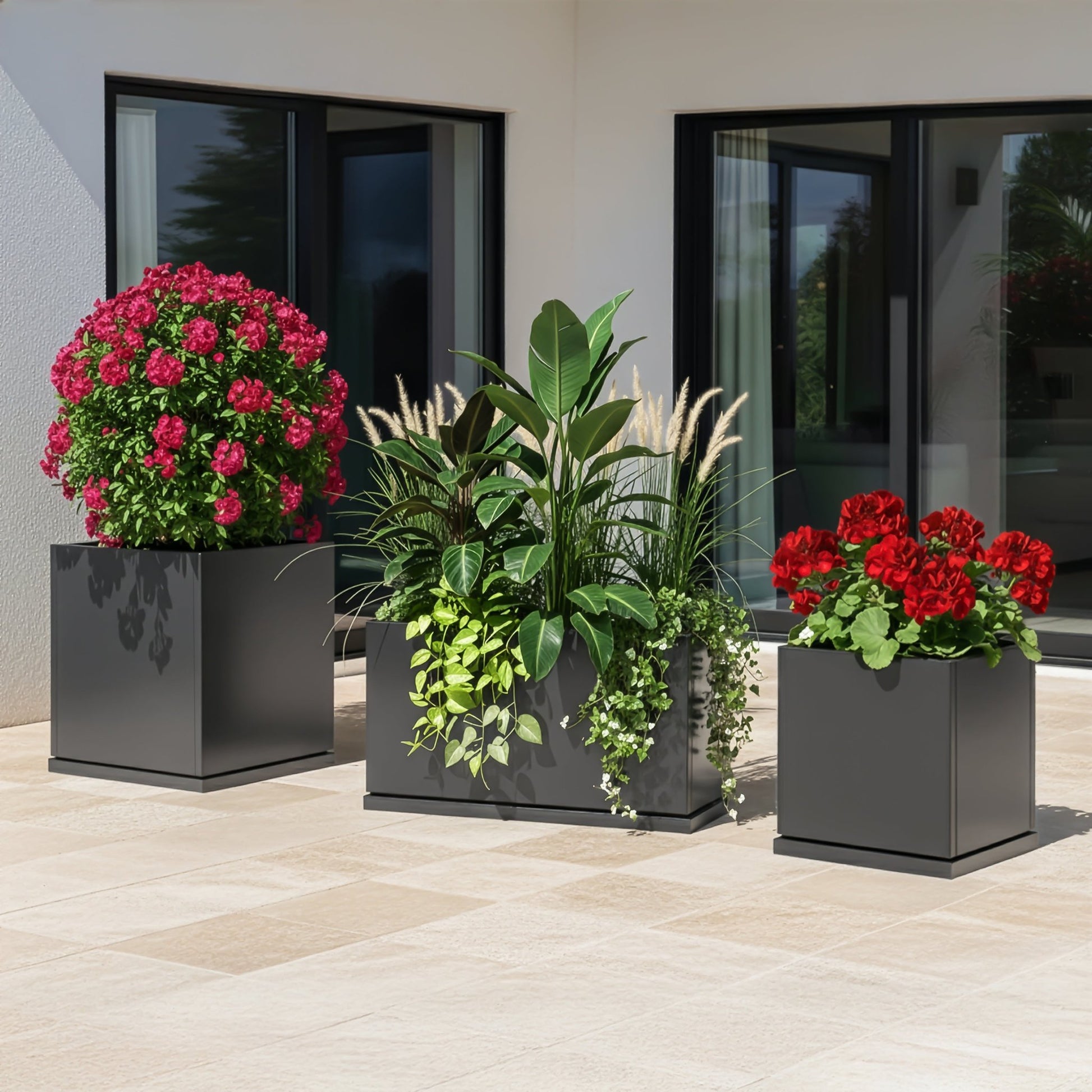 Three H Potter grey planters with flowers on a contemporary patio
