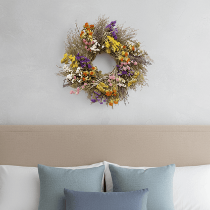 spring botanical wreath above a bed 