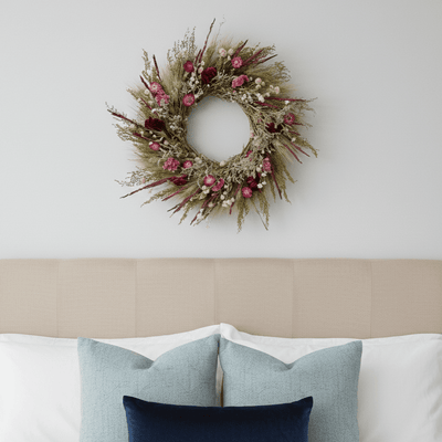 decorative spring wreath with bright seasonal botanicals above a bed
