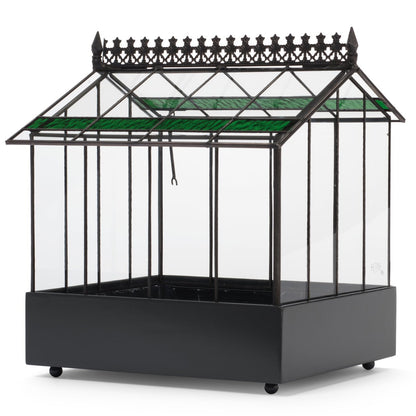 A detailed close-up of the intricate Victorian-style metal cresting along the ridge of the H Potter glass terrarium roof.