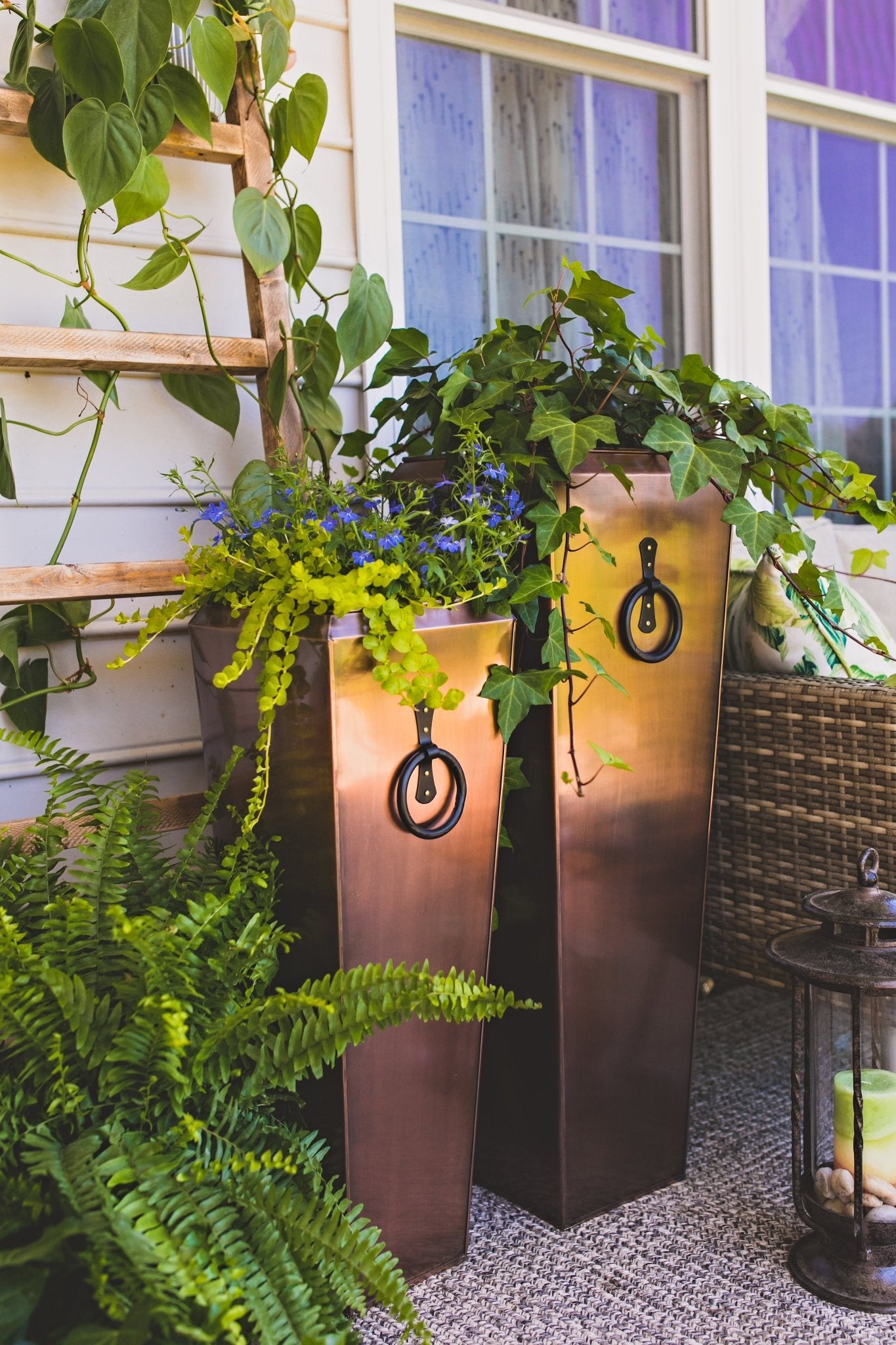 H Potter Planters Tall Antique Copper planters - Set of 2 filled with greenery and on a porch