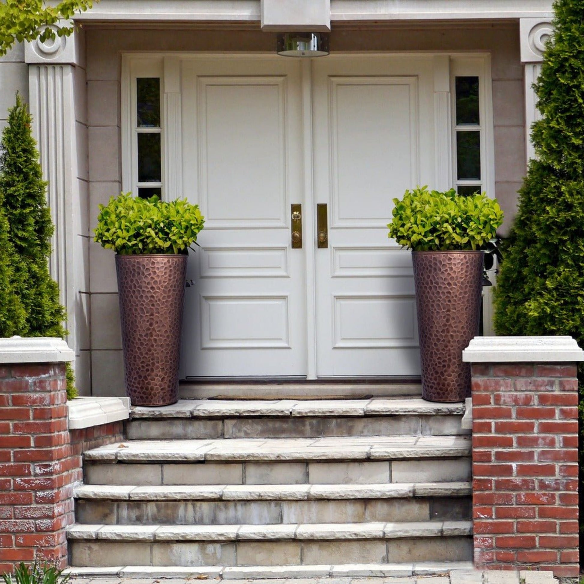 H Potter tall hammered copper planter with flowers on front porch entryway